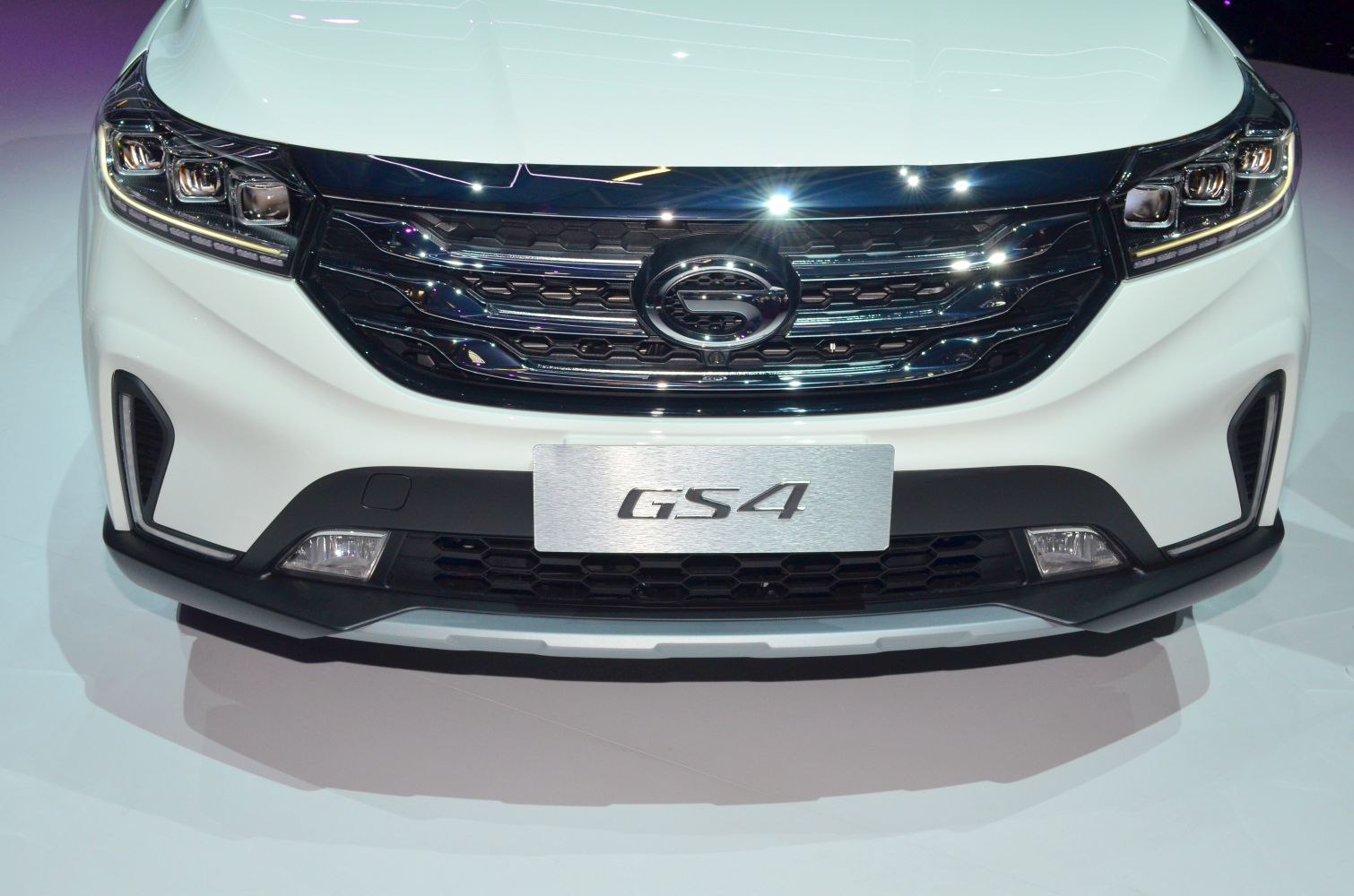 Close-up of front grille, headlights, and logo on vehicle front end.