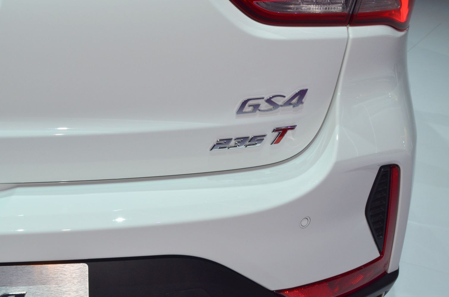 Close-up of rear badge and tail light section on a white vehicle