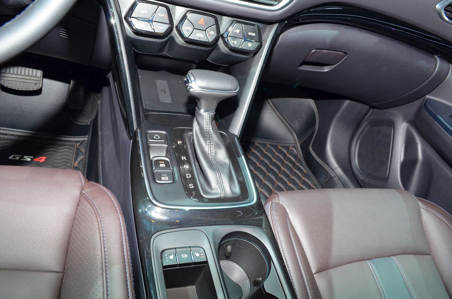 Close-up of gear shifter, central console, and leather seats
