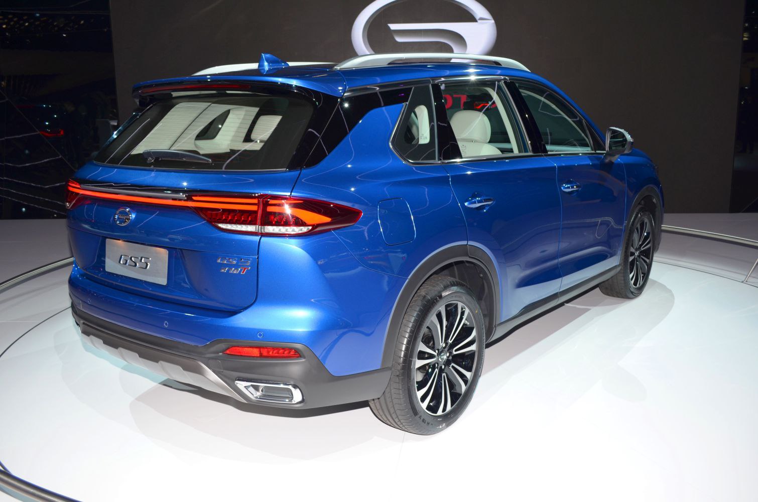 Rear view of blue SUV with LED tail lights and sporty exhaust