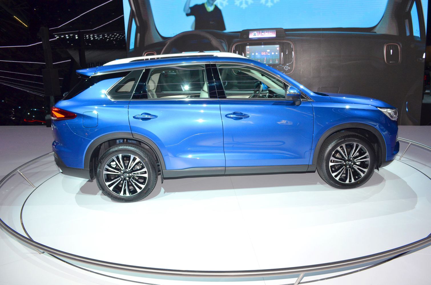Blue SUV side view with alloy wheels on display platform