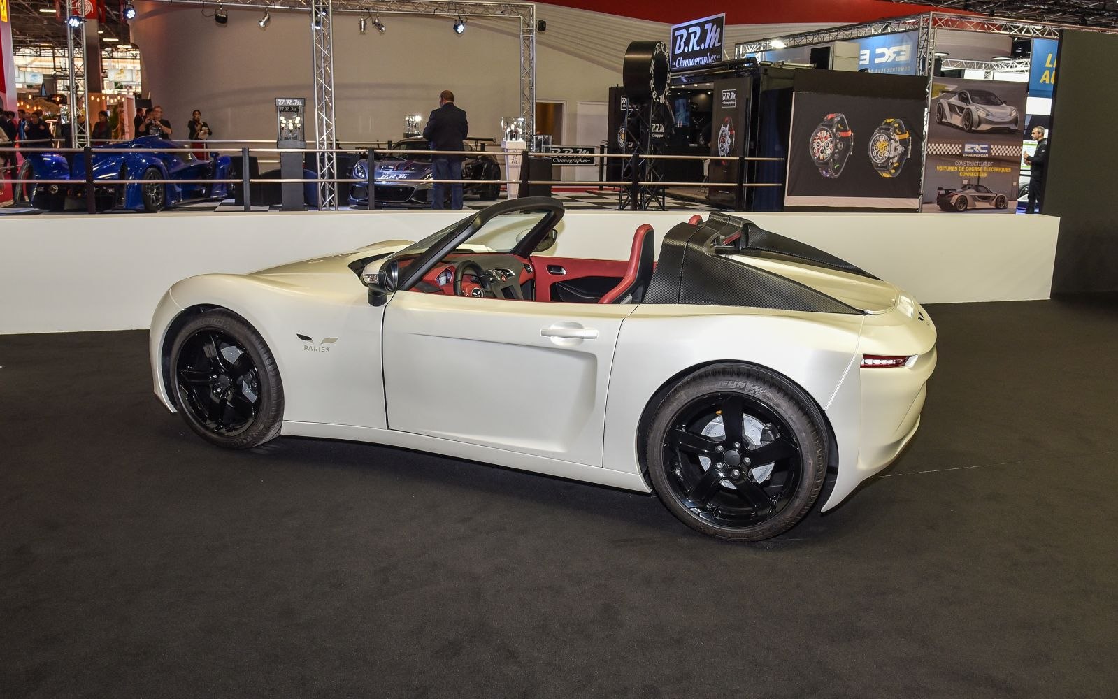Convertible electric roadster with black wheels and red interior