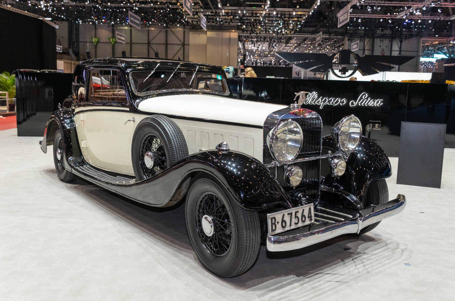 Vintage luxury sedan with rounded fenders and dual spare tires