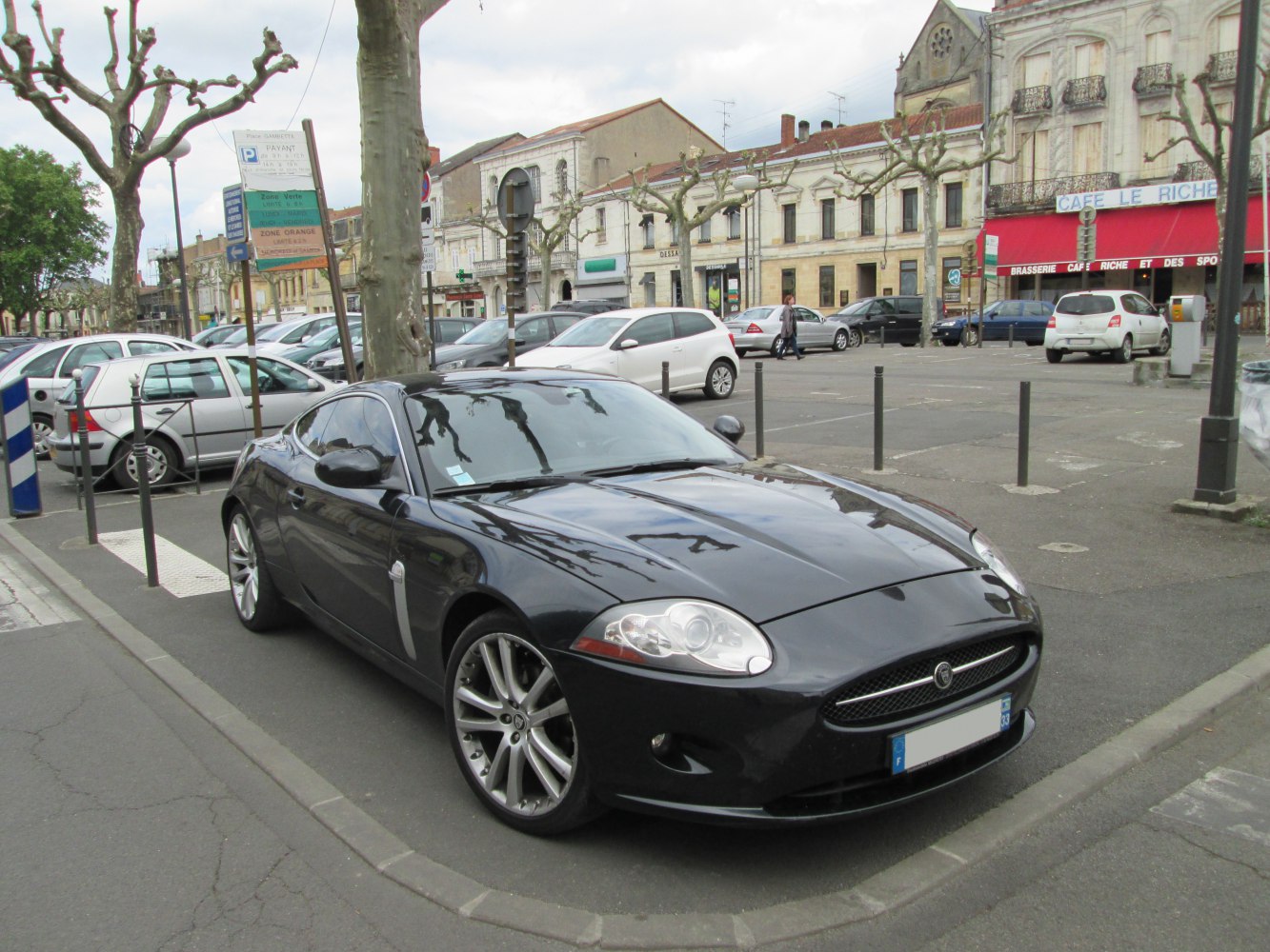 Black coupe with sleek design and alloy wheels parked on street