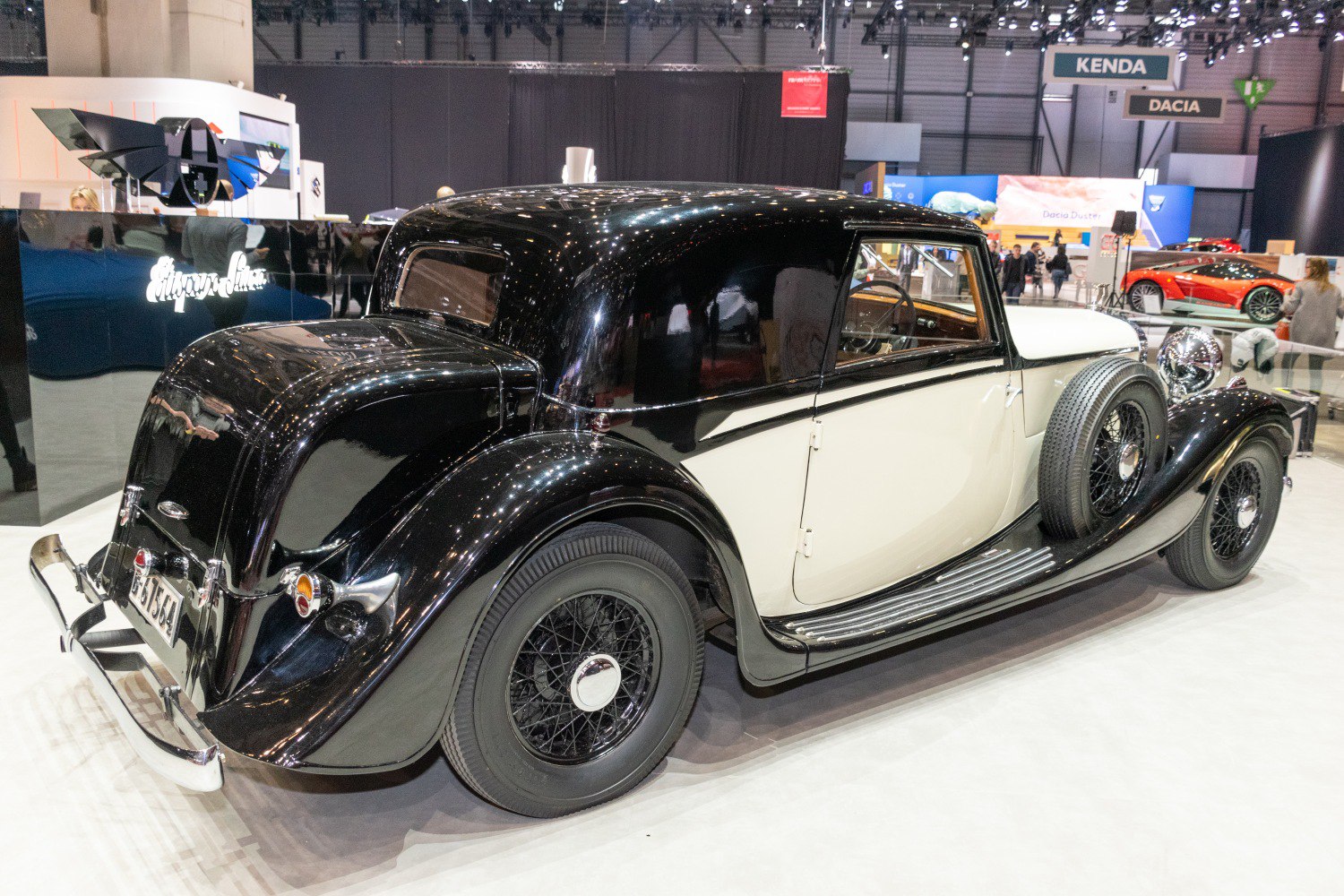 Black and white vintage coupe with wire-spoke wheels and two-tone paint