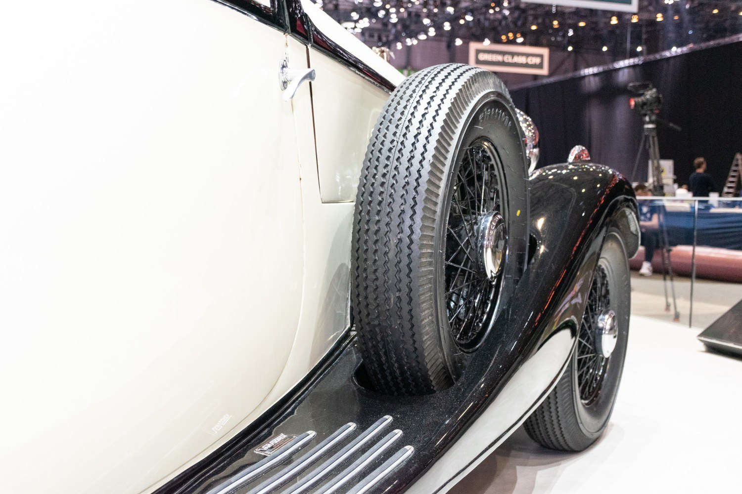 Close-up of side mounted spare wheel and running board with wire spoke wheel.
