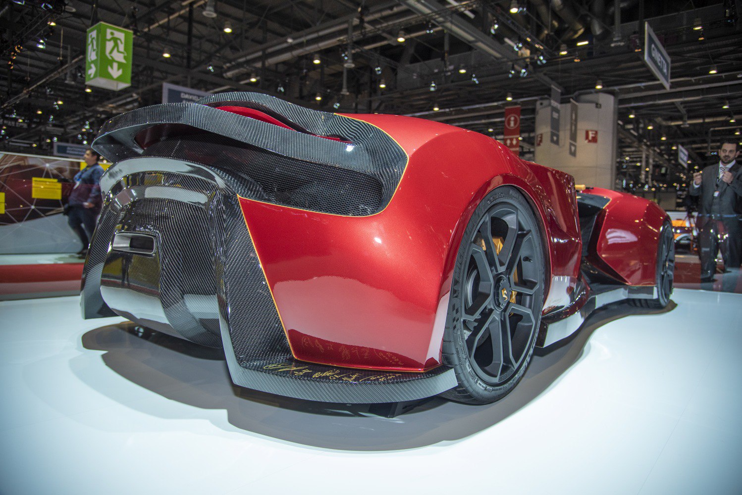 Red rear sports vehicle with carbon fiber spoiler and black performance wheels