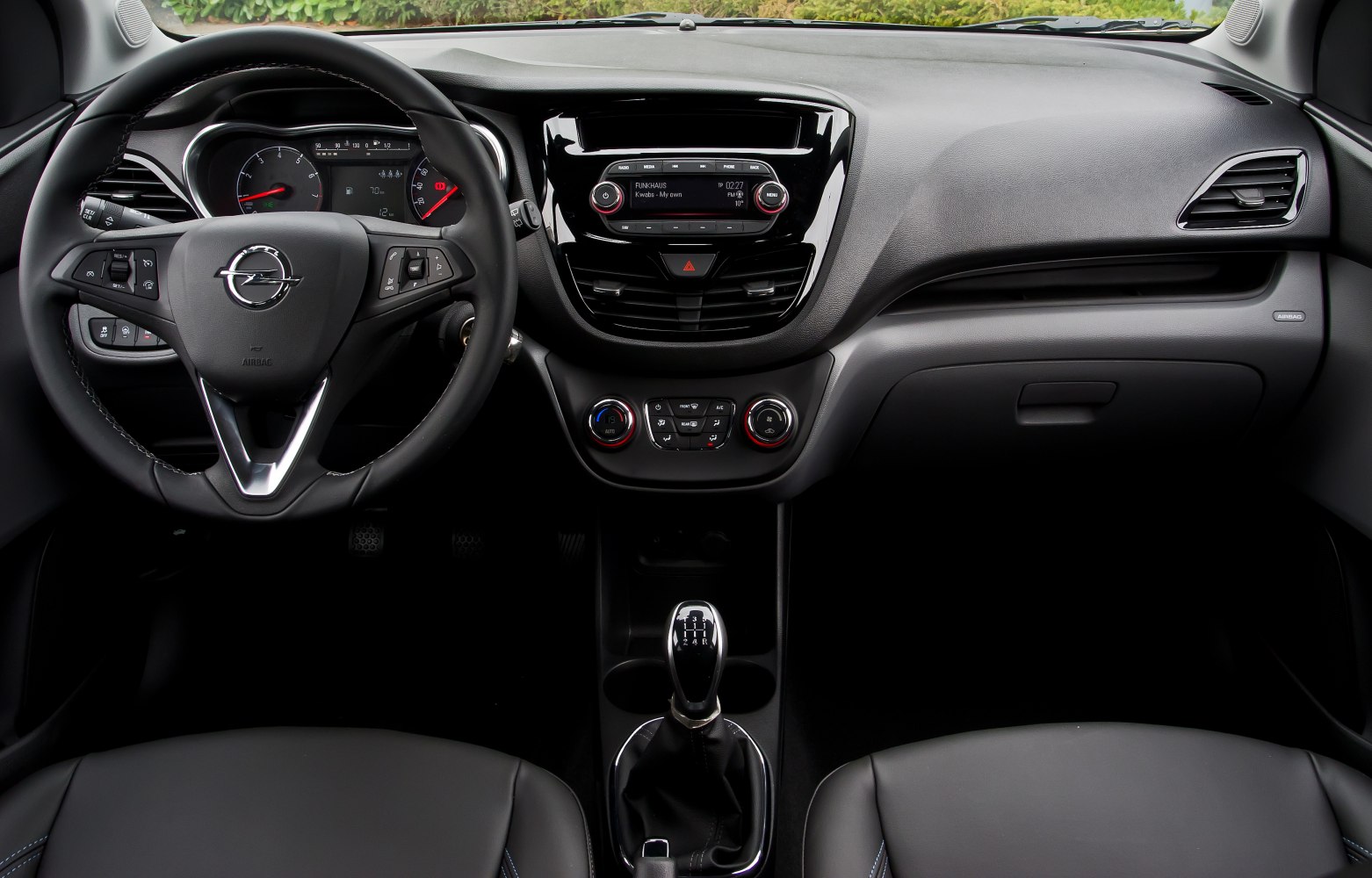 Dashboard, steering wheel with controls, and manual gear shift