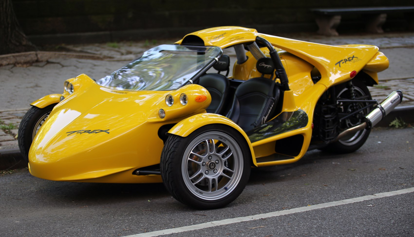 Yellow three-wheeled sporty vehicle with dual seats and aerodynamic form