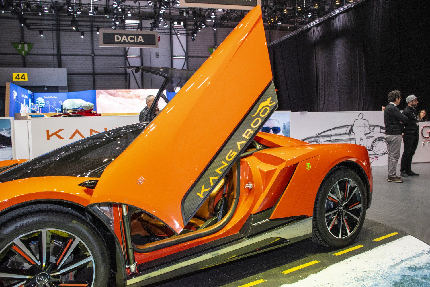 Orange electric sports car with butterfly doors open