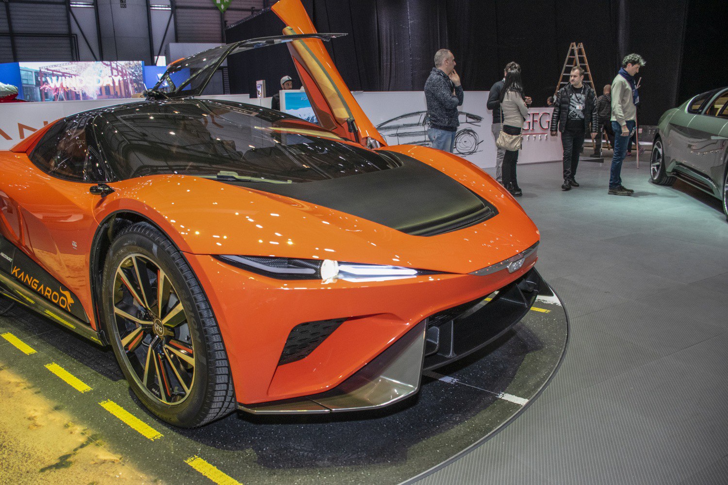 Orange concept car with gullwing doors and aerodynamic shape