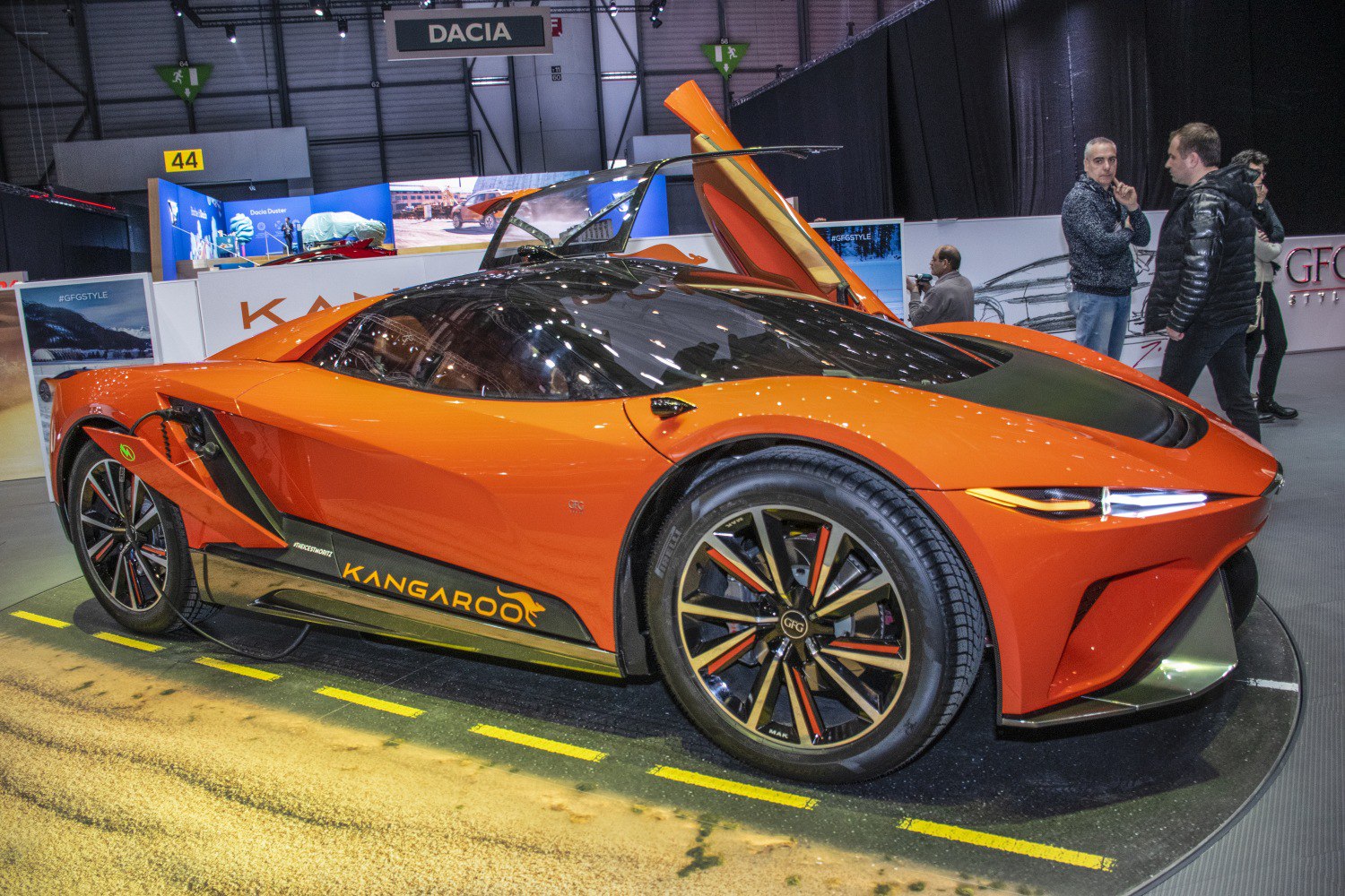 Orange electric sports car with gullwing doors and sleek aerodynamic design