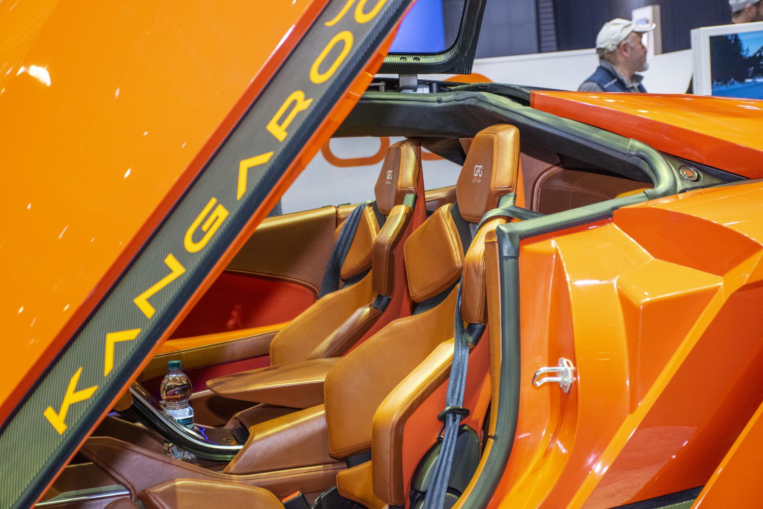 Leather seats and falcon wing door in orange futuristic sports car