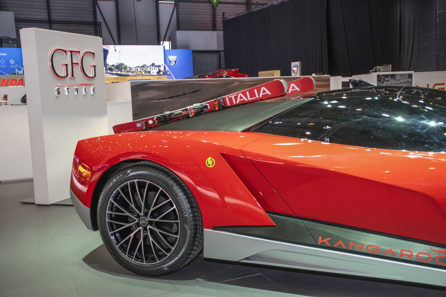 Rear side of red vehicle with ski rack and detailed wheel design