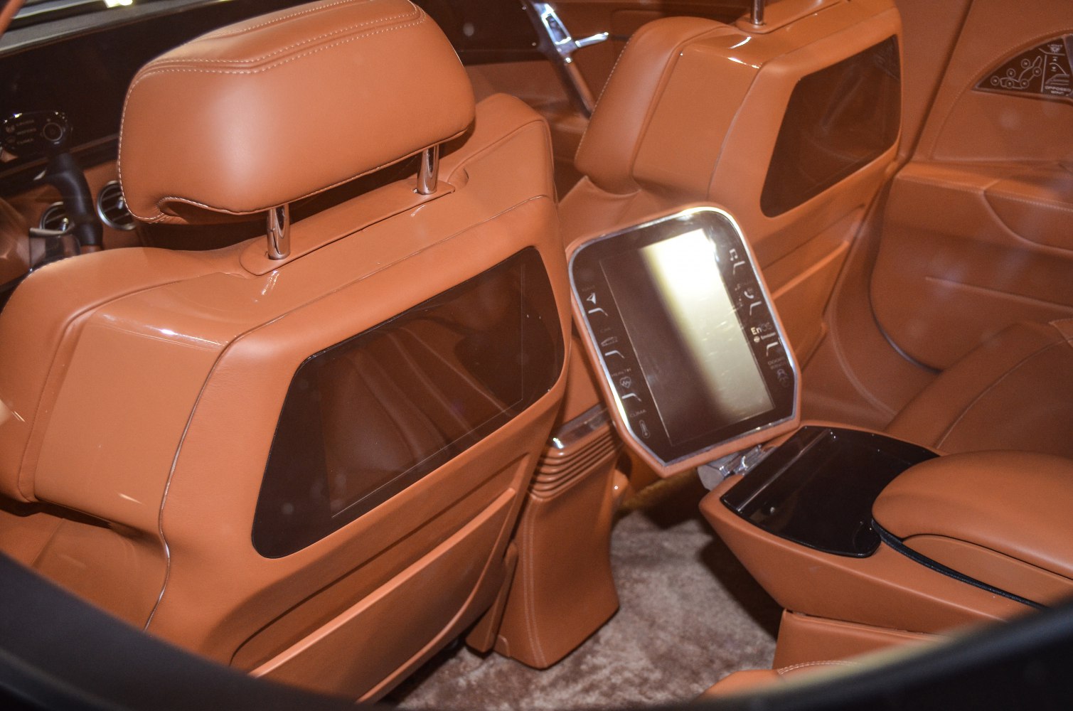 Tan leather rear seats with integrated displays and rear touchscreen control panel