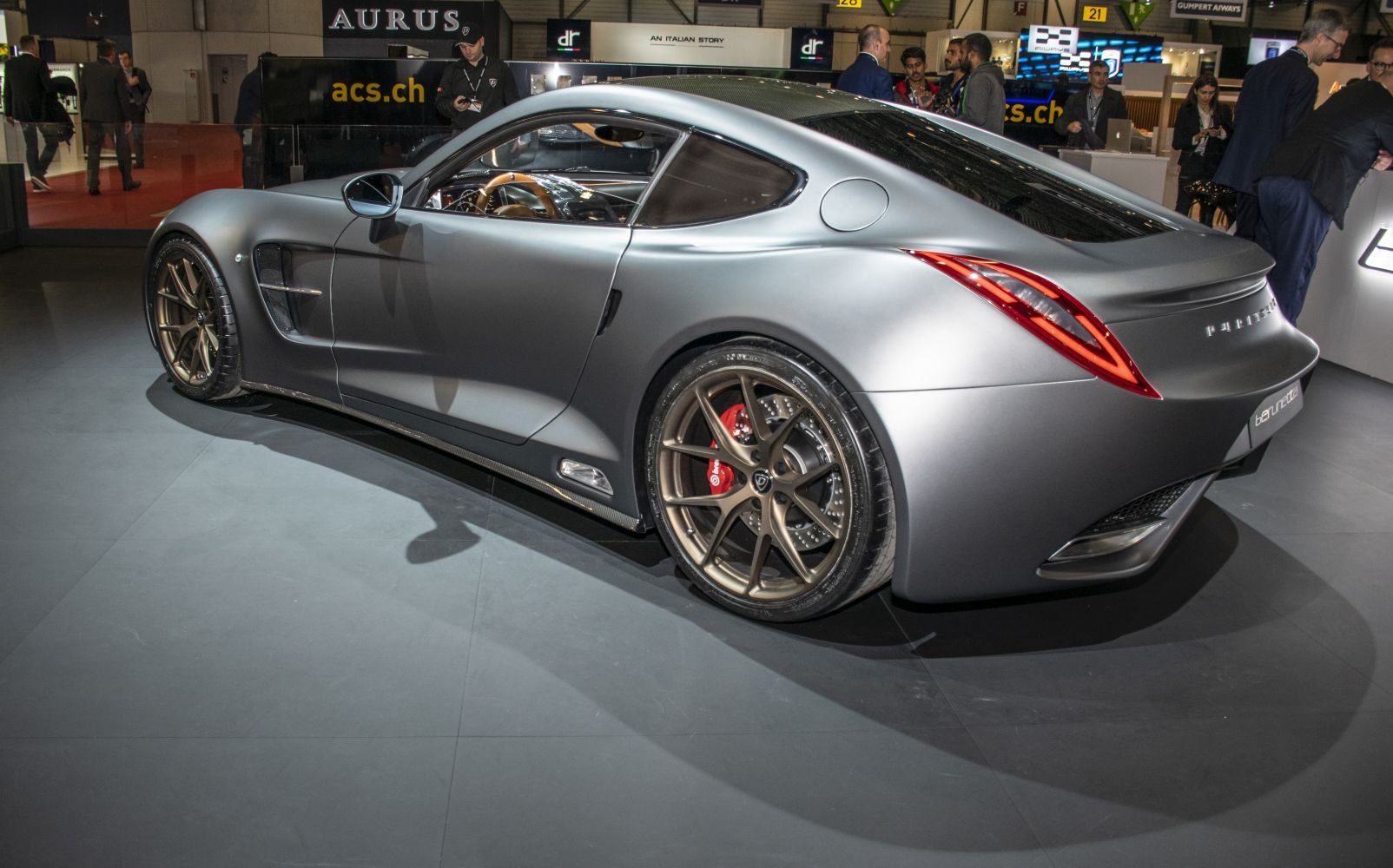 Rear and side view of matte-finish sports coupe with bronze wheels and aerodynamic design