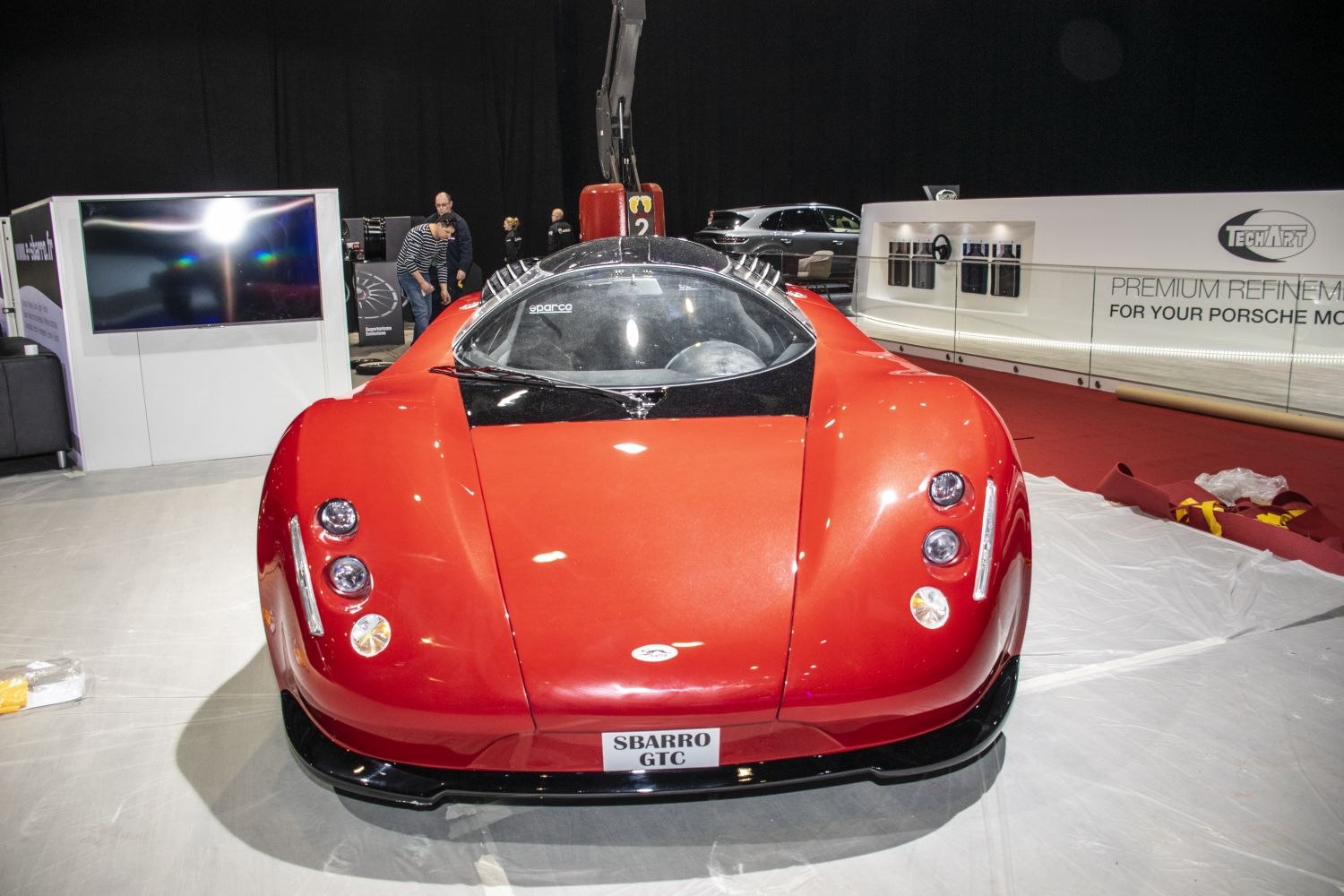 Front view of red sports coupe with clear windshield and triple headlights