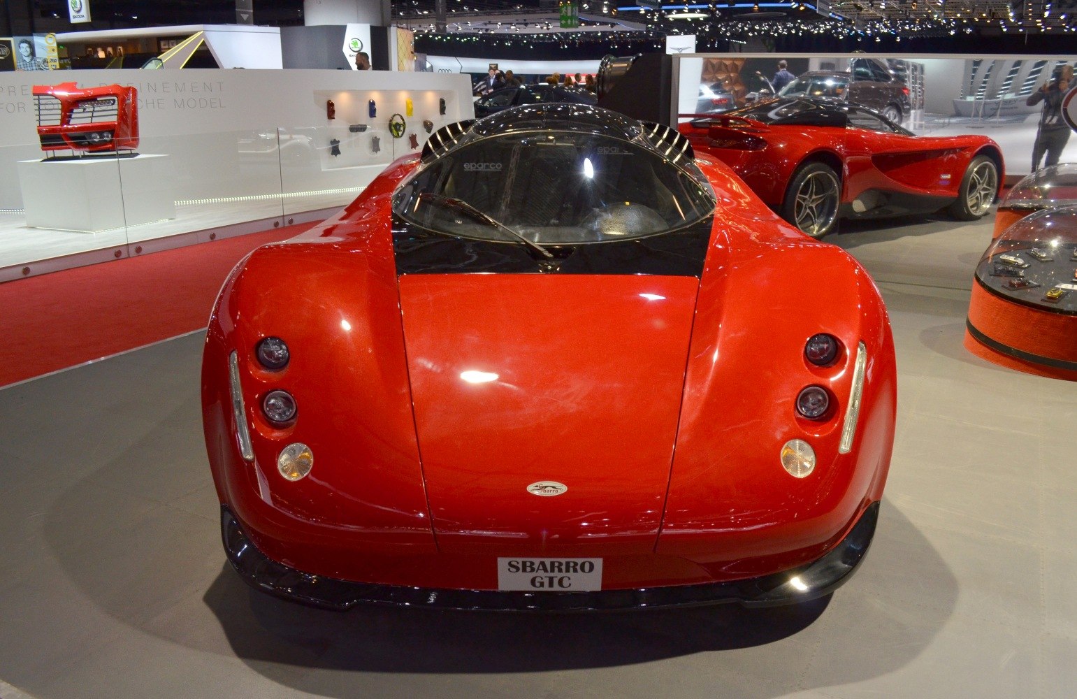 Front view with round headlights and curved hood in bright red.