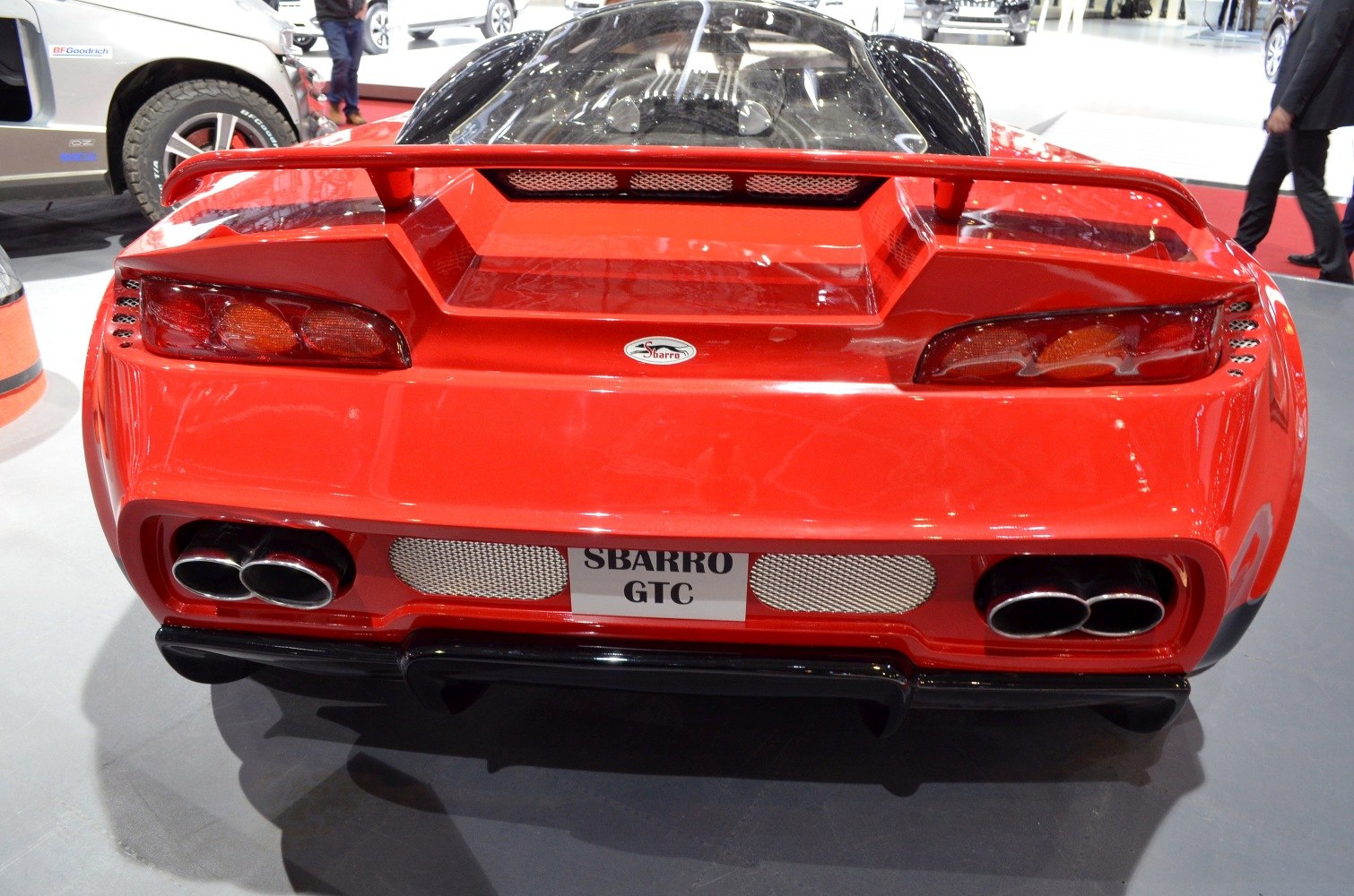 Red sports car rear with quad exhaust and distinctive taillights