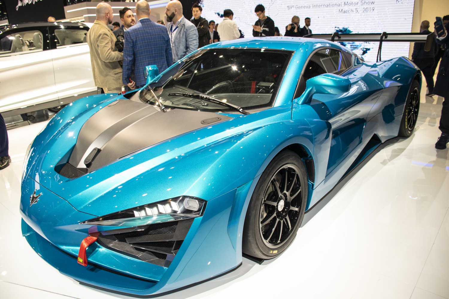 Metallic blue electric sportscar with carbon hood and slick racing tires