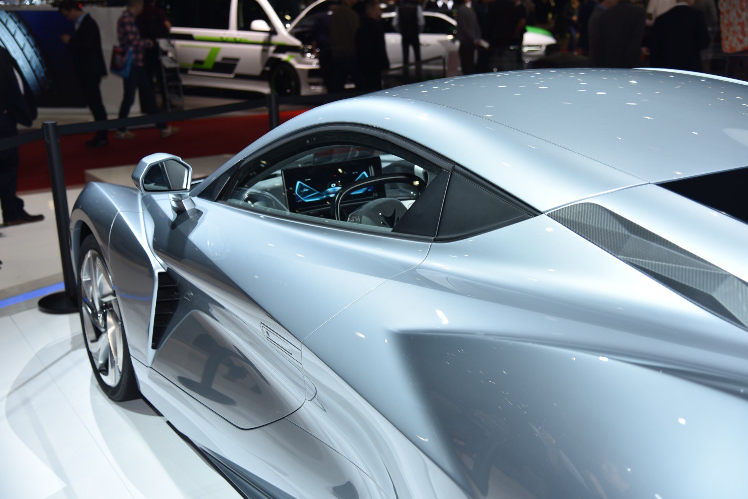 Silver sports coupe side view with aerodynamic vents and digital cockpit