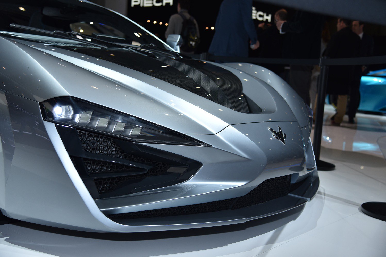 Close-up of sharp LED headlights and carbon fiber hood on a sleek front end