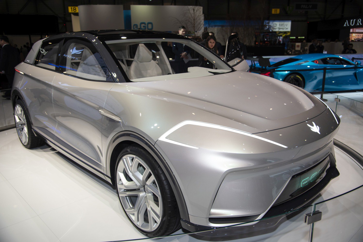Silver electric SUV with sleek LED lights and futuristic multi-spoke wheels