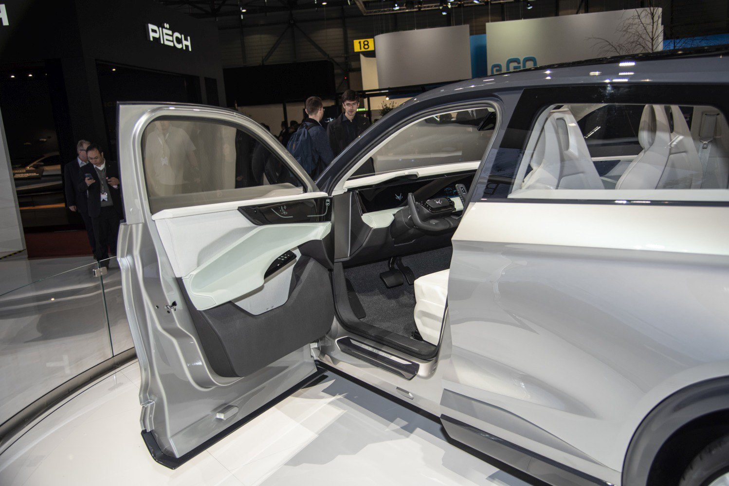 Open front door revealing modern white interior and digital dashboard