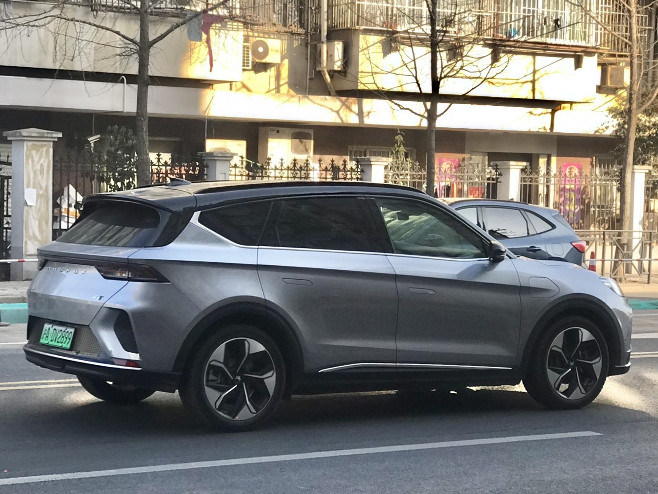 Side view of a sleek electric SUV with a high roofline and futuristic alloy wheels