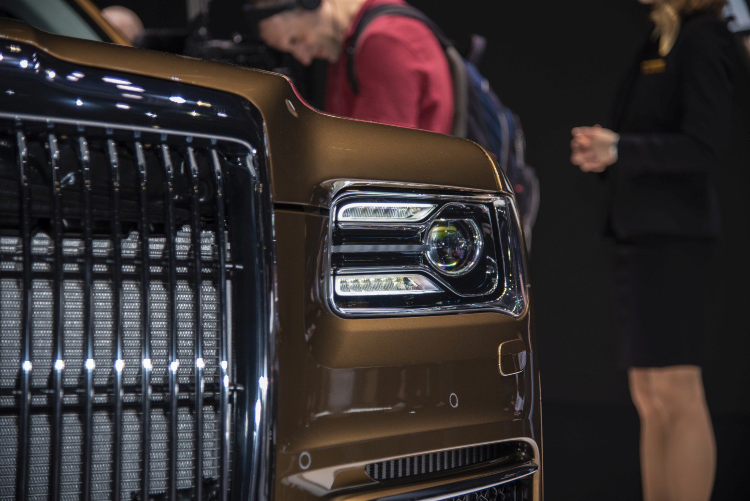Close-up of luxury vehicle headlight and grille with sleek design