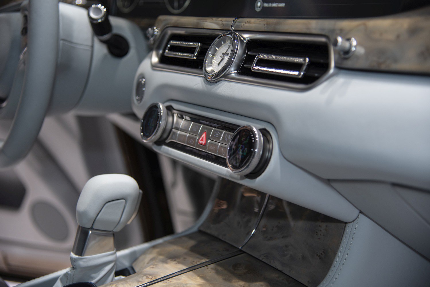 Luxury car dashboard with analog clock and dual climate control knobs