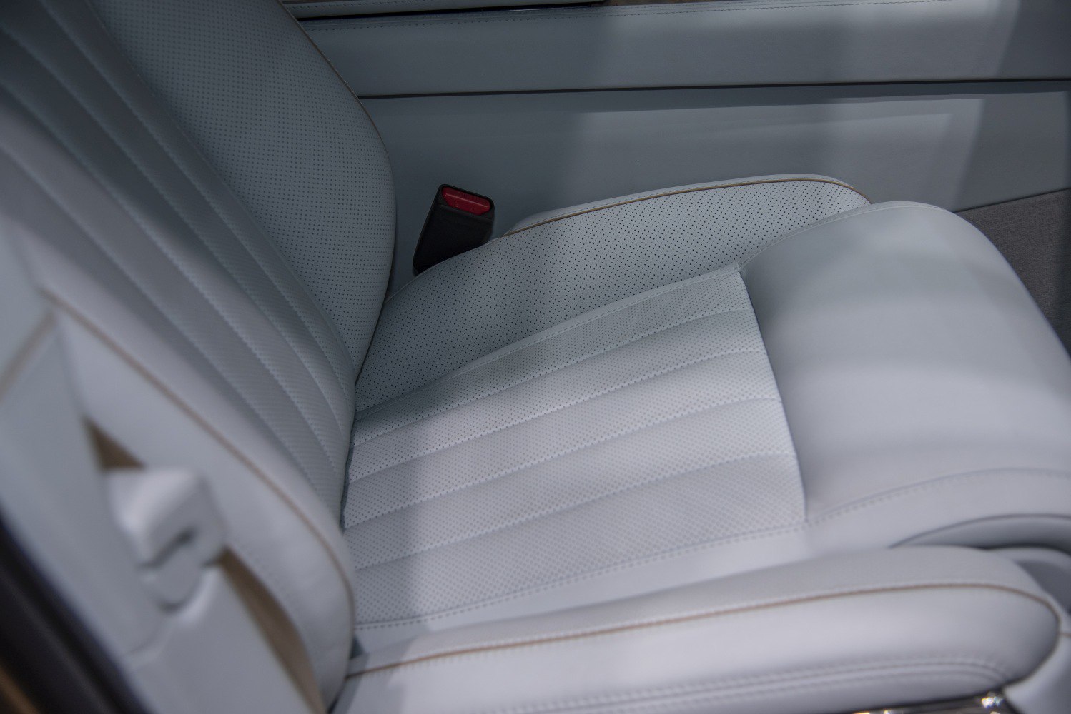 Perforated white leather car seat with premium stitching and ergonomic design