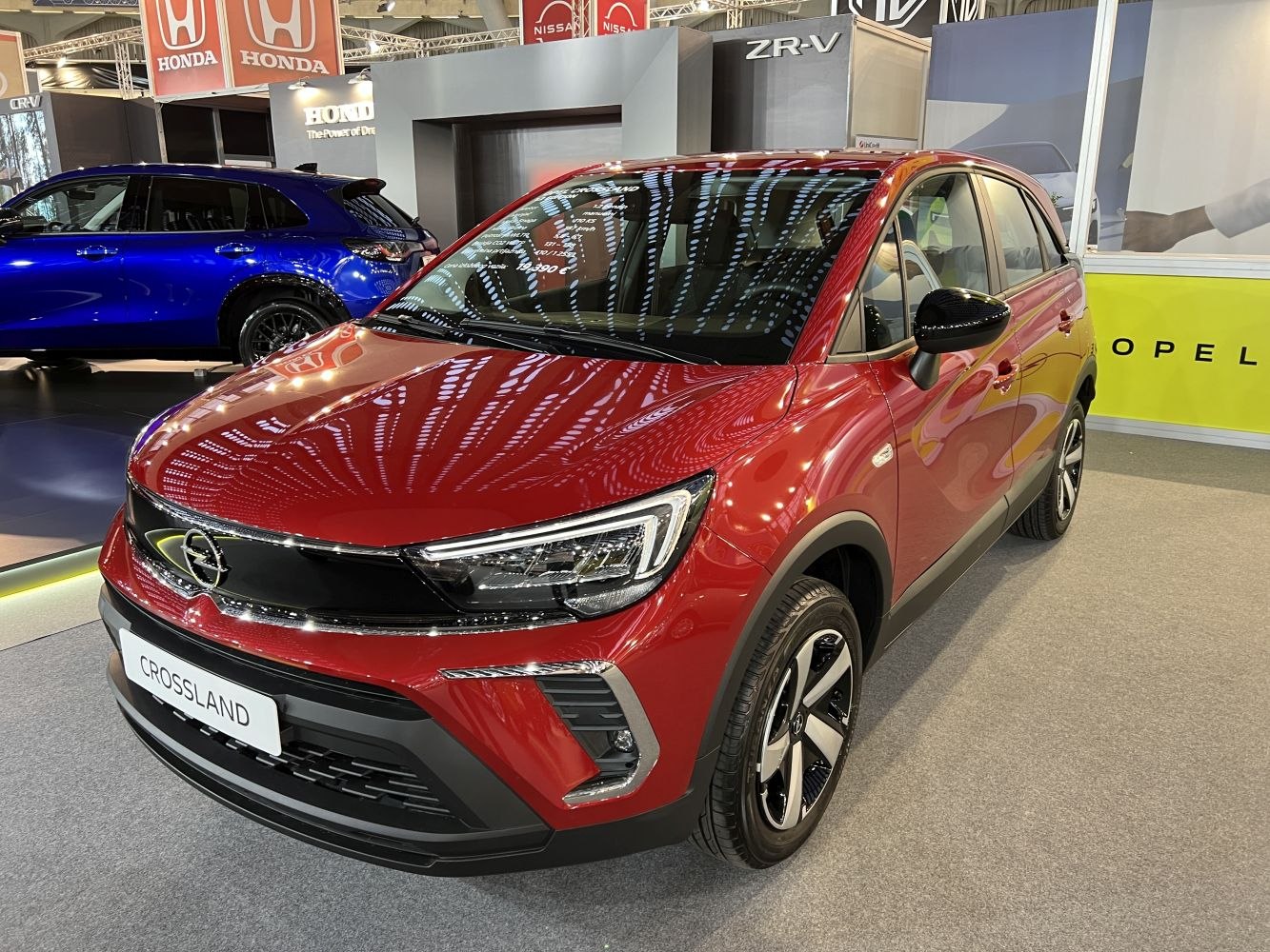 Red crossover showing facelift front fascia and alloy wheels.