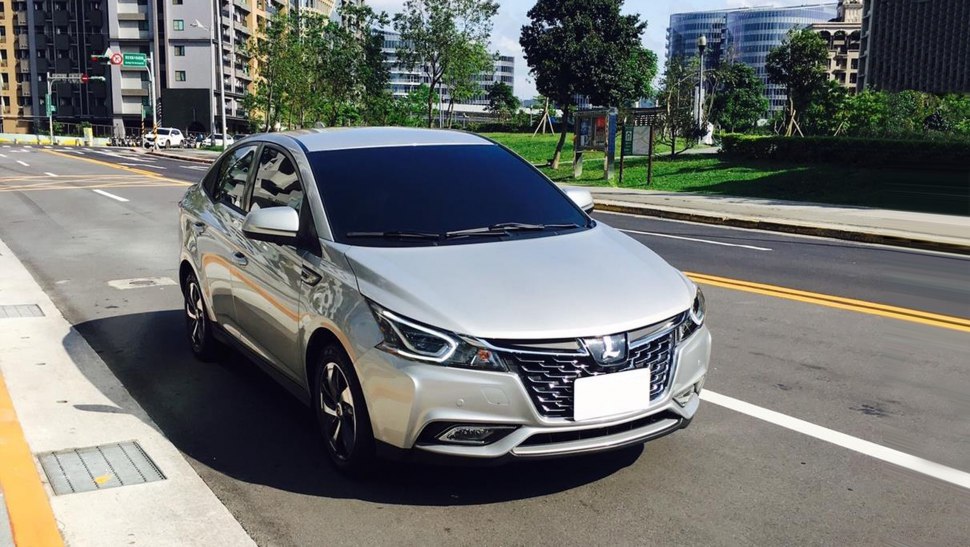 Front and side view of a silver sedan parked on a road