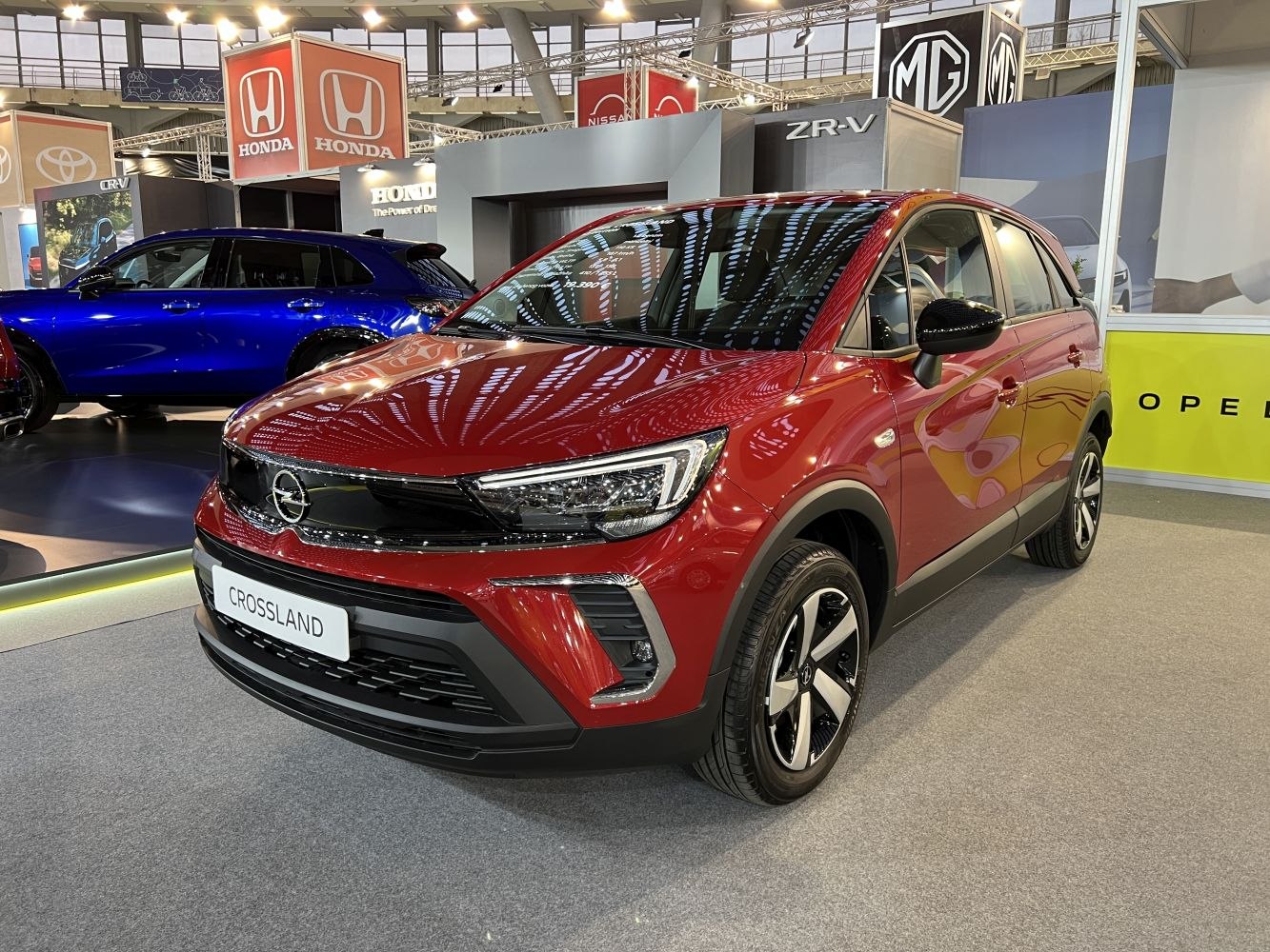 Red compact SUV front-side view with LED headlights and modern grille