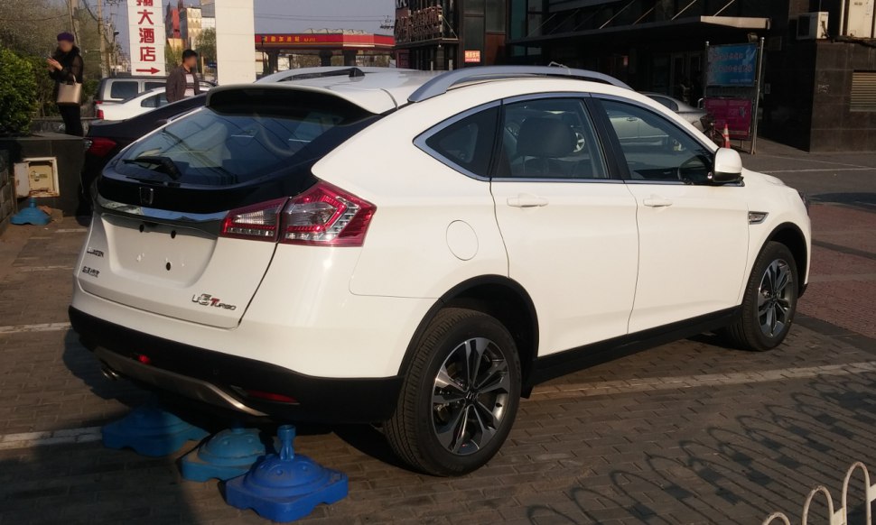 White crossover rear side view with tinted glass and modern tail lights