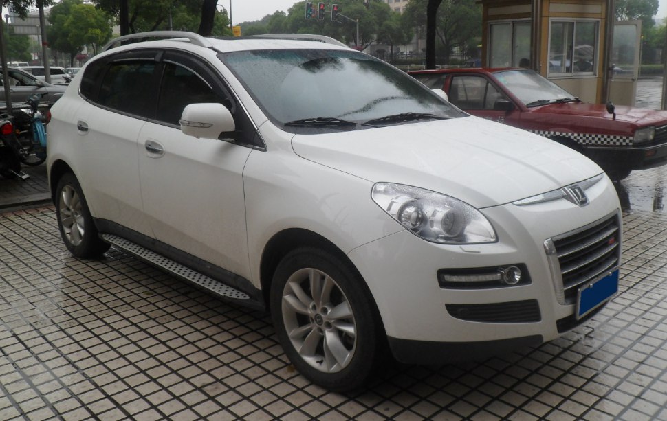 Front side profile view of white SUV with headlights and alloy wheels