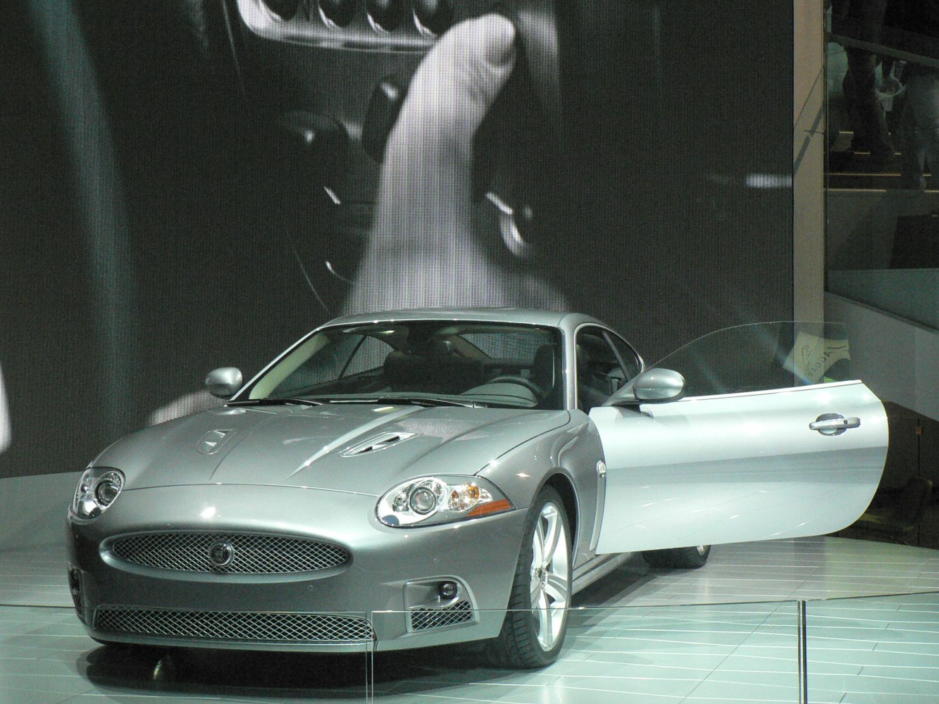 Silver sports coupe with open driver's door and aerodynamic body
