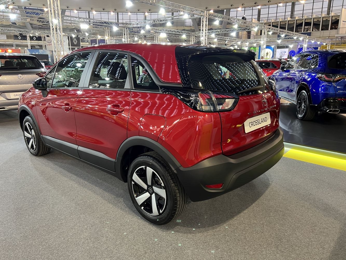 Rear and side exterior view of a red compact SUV with black roof and alloy wheels
