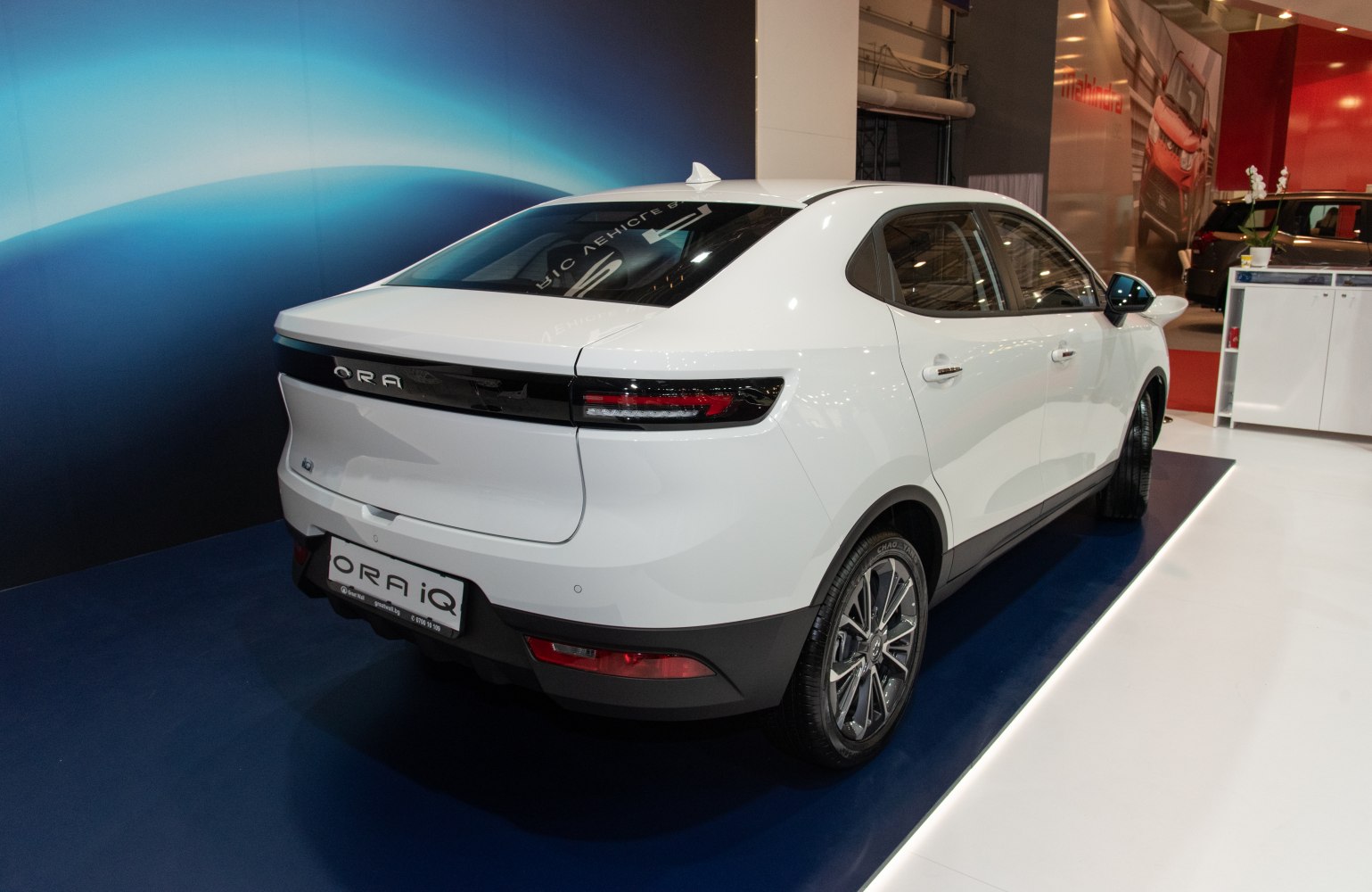 Rear view of modern white electric crossover with LED taillights