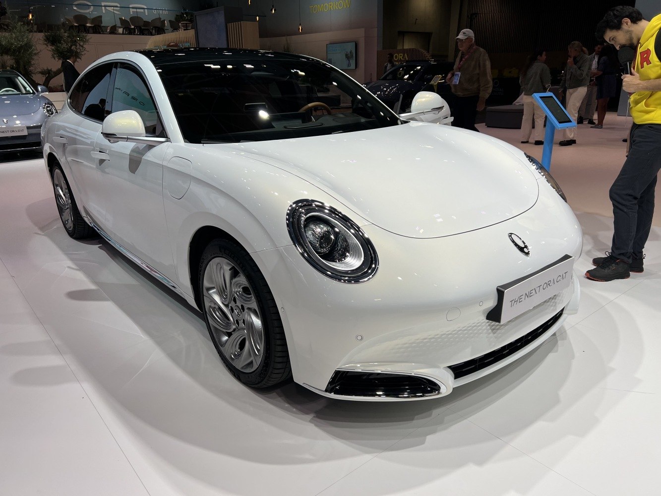 Electric sedan with round retro headlights and sleek white body