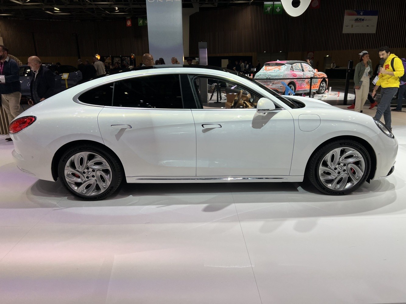 Side profile of sleek white electric sedan with distinctive alloy wheels