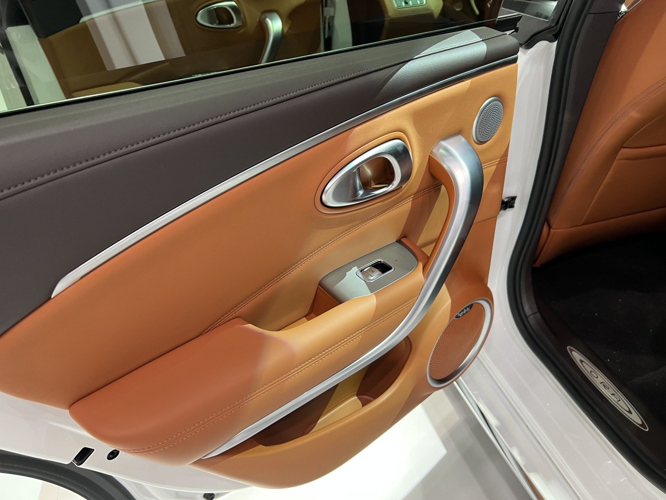 Premium car interior door panel with leather and metallic handle