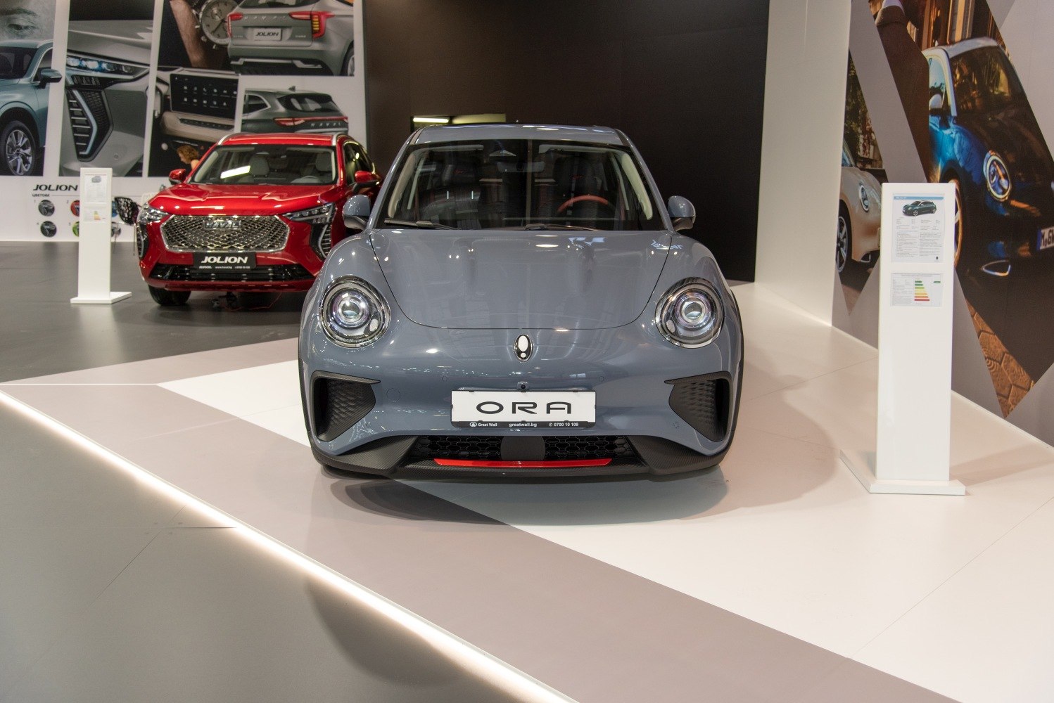Front view of an electric vehicle with round headlights and smooth aerodynamic fascia.
