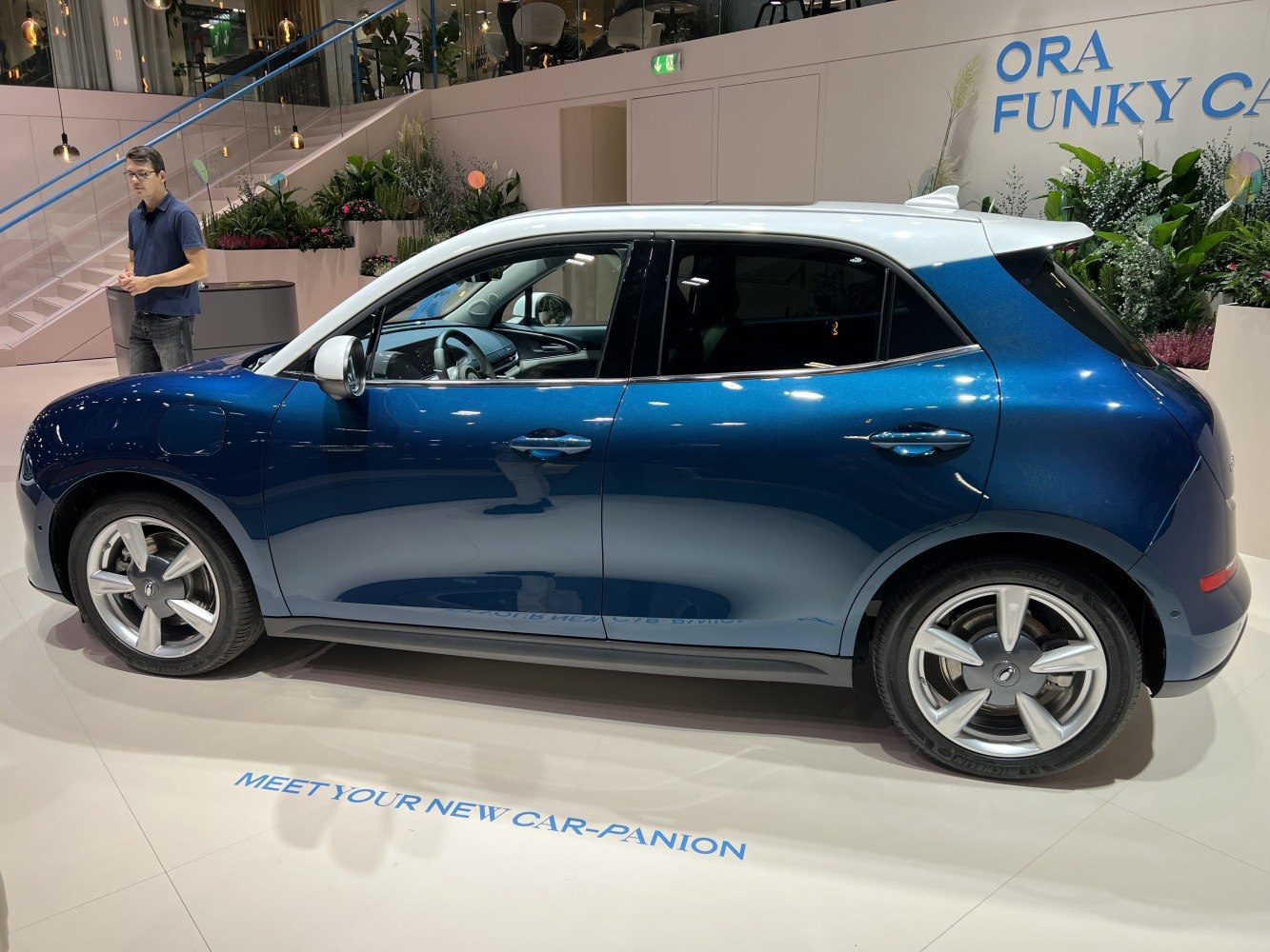 Side profile of two-tone blue and white compact hatchback with alloy wheels