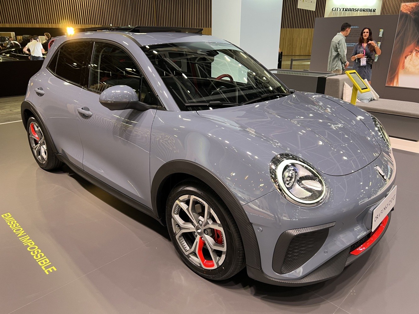 Round LED headlights and red-accented alloy wheels on an electric hatchback