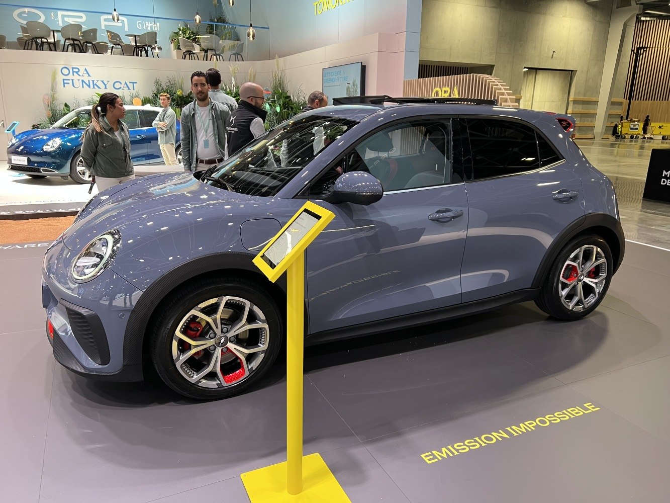 Compact electric hatchback with round headlights and sporty alloy wheels.