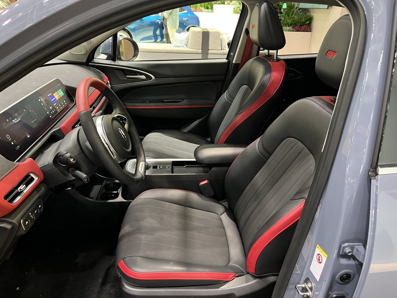 Black and red front seats with digital dashboard and multifunction steering wheel