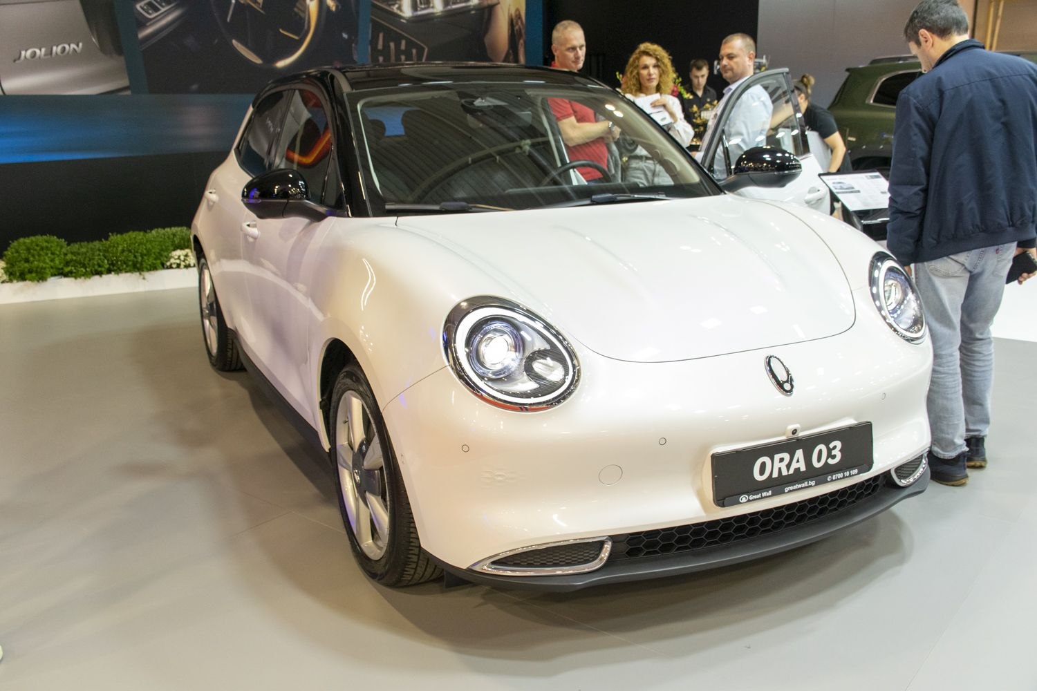Modern electric car front with round LED headlights and sleek styling