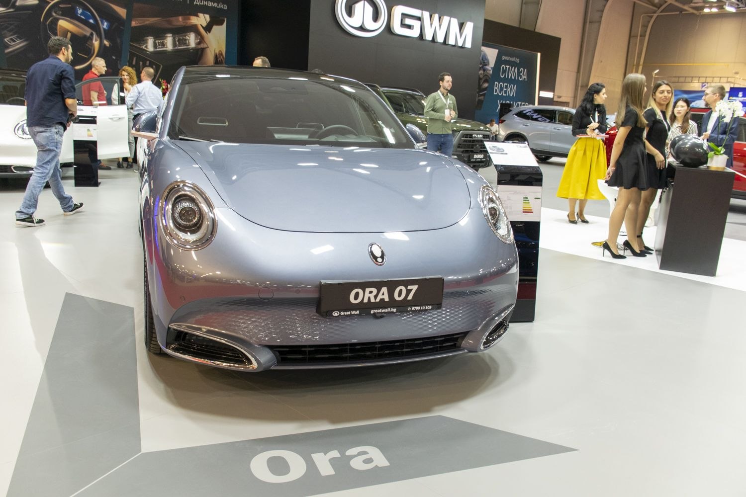 Front view of sleek EV with round headlights and smooth hood design.